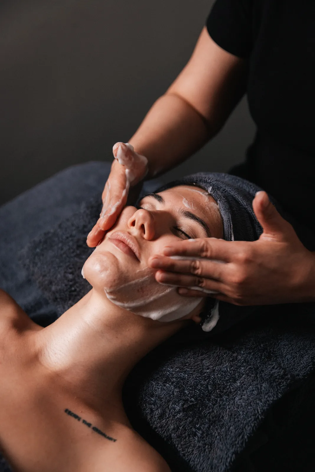 A therapist massaging a client’s face during a facial