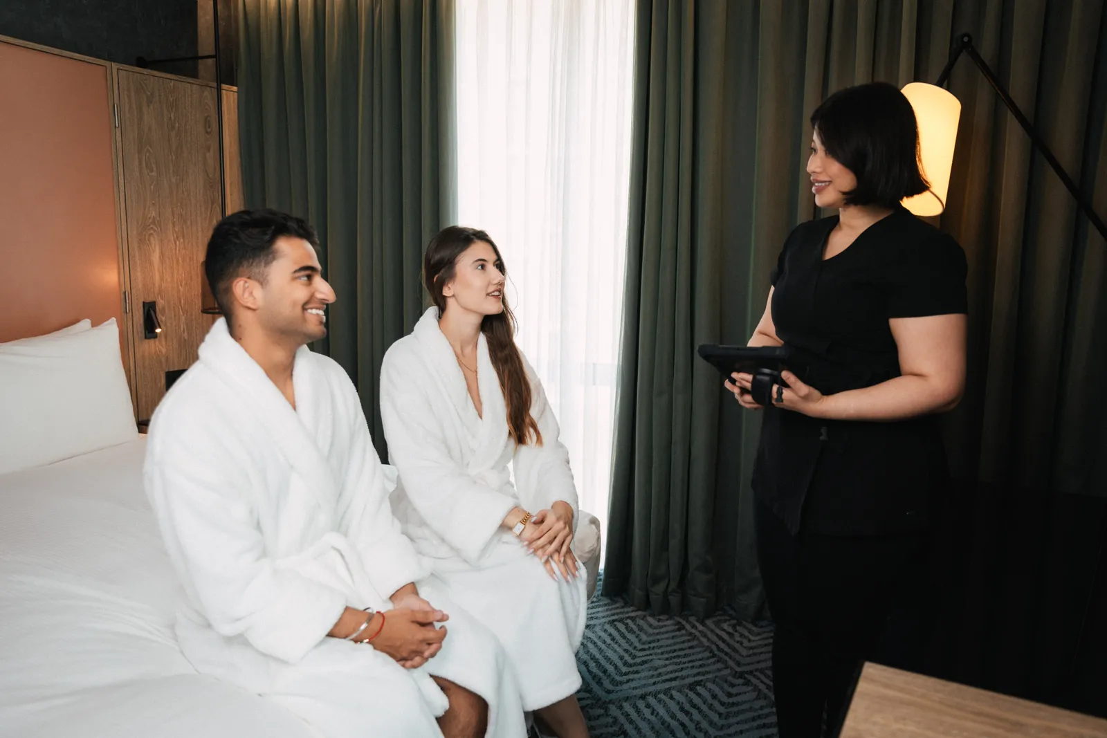 A therapist talking two guests in robes through their treatment