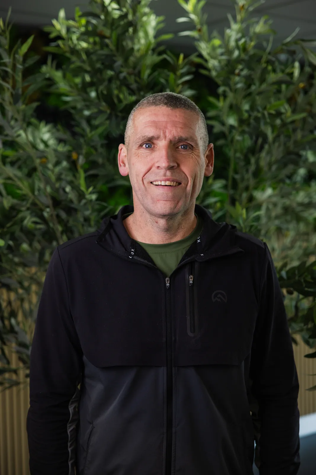 Portrait of a padel coach in front of green plants